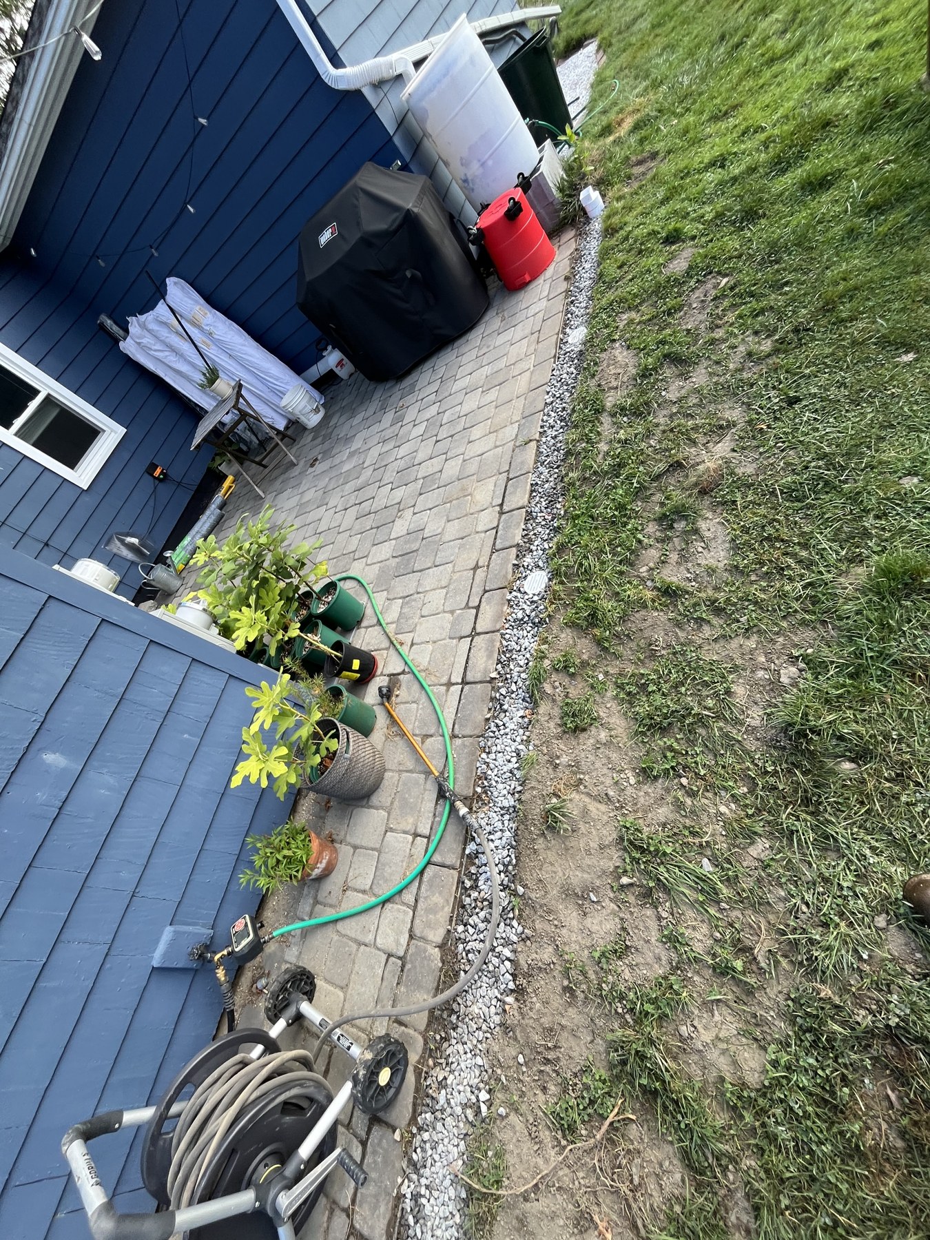 Stone drainage border beside a patio by Blue Line